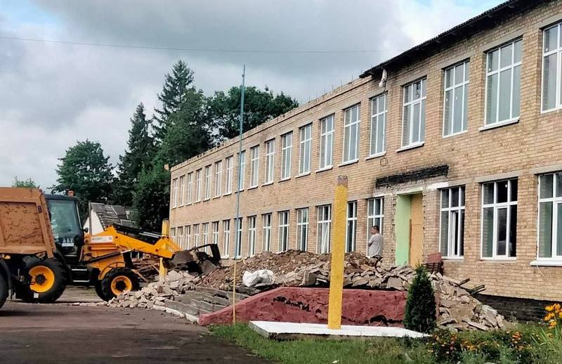 Трактор розбирає будівельне сміття біля центрального входу до Ніжиловицької гімназії під час демонтажу ганку.