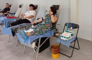 Дві жінки та чоловік лежать у донорських кріслах вздовж світлої стіни кабінету під час процедури донації. Поруч розташоване спеціальне медичне обладнання для забору крові.