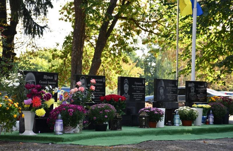 Пам’ятні стенди з портретами загинулих захисників України та квіти на Алеї пам’яті у Рожеві